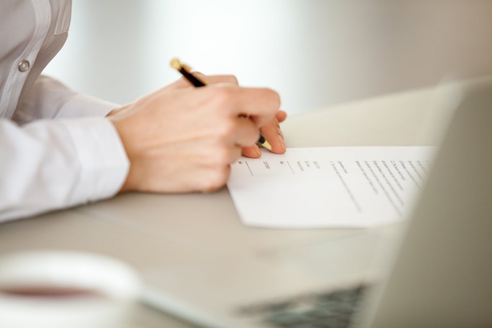 Photo of a Woman Signing Papers